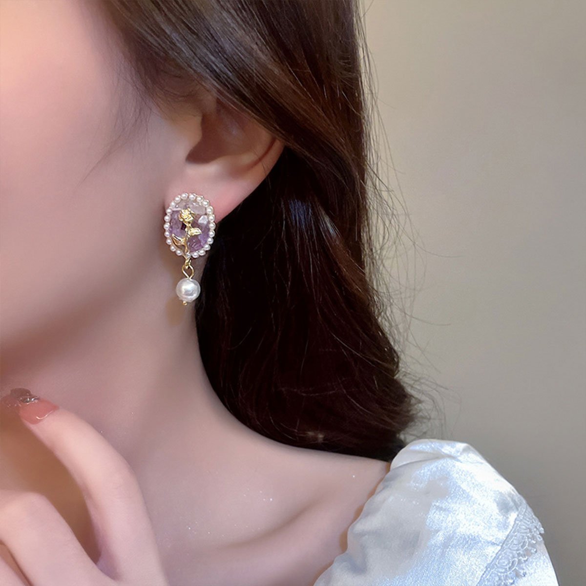 Vintage-inspired floral earrings with pearl drops.