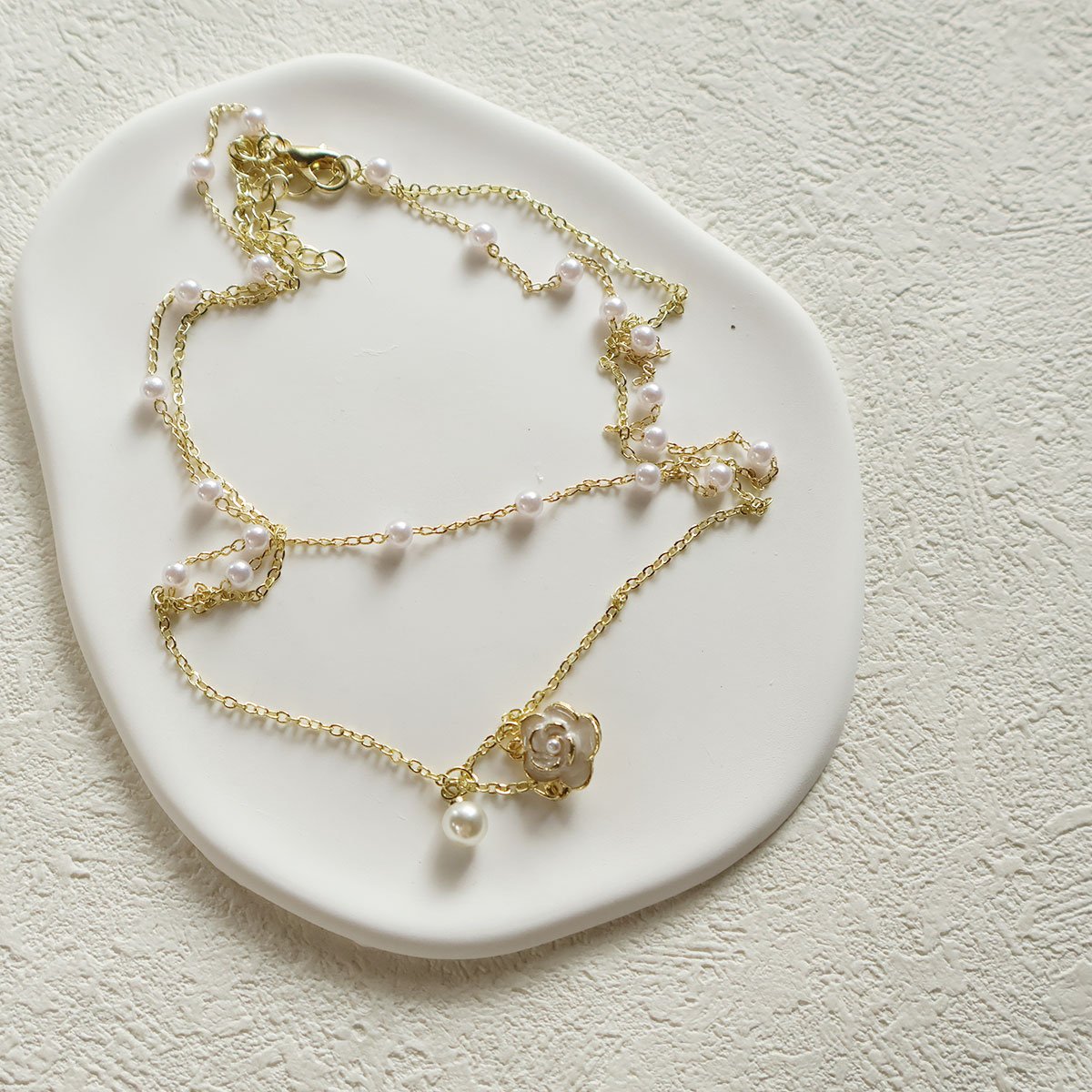 Elegant Multi-Layer Pearl Necklace with Floral Pendant on model